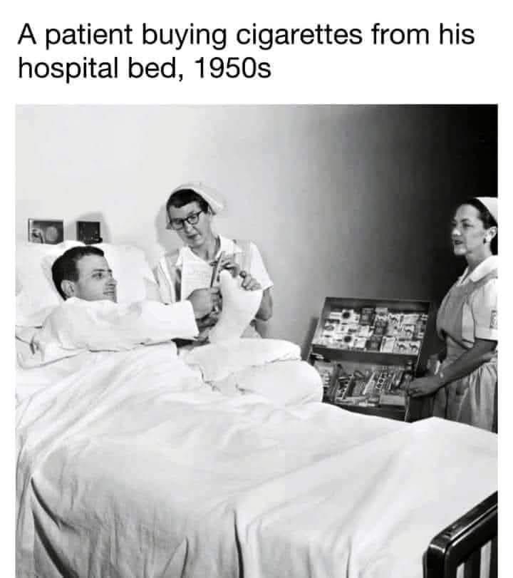 A black-and-white photo from the 1950s shows a man in a hospital bed reaching out to purchase cigarettes from a nurse…