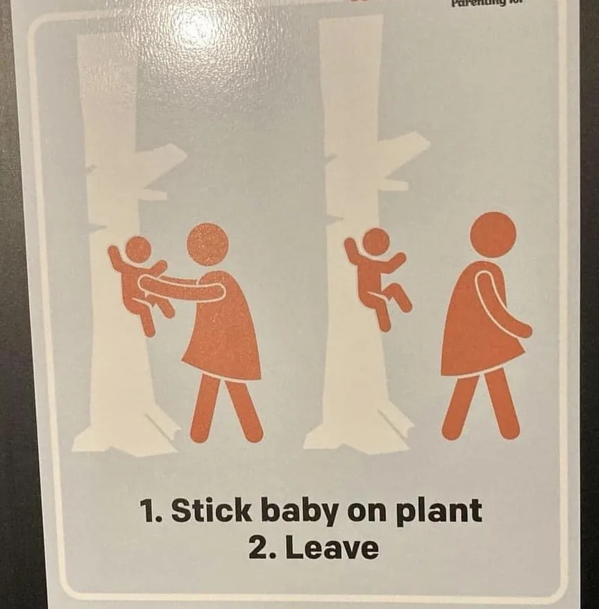 A public sign with orange stick figures shows a parent holding a baby against a tree, then walking away as the baby clings…