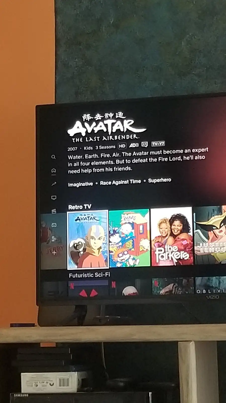 A TV screen displays the Netflix show 'Avatar: The Last Airbender' with its description text overlaid. The description…