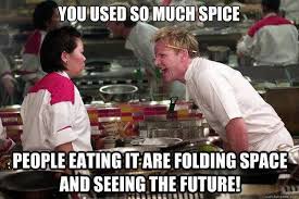A still from a cooking show featuring two chefs in white and red uniforms. The chef on the right, with blonde hair, is…