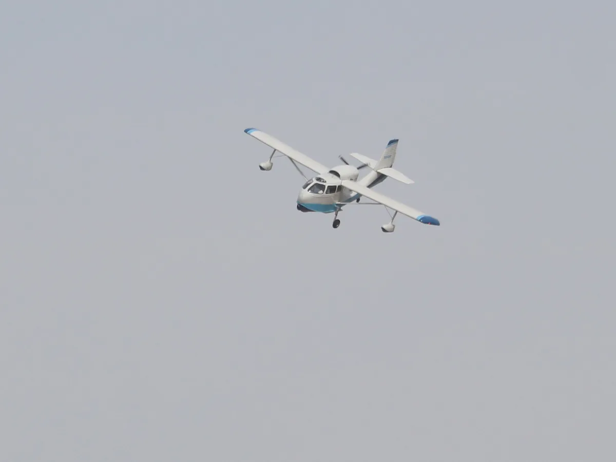 A small white and blue single-engine airplane with floats is flying against a gray sky. The overlaid text reads 'i'm not a…