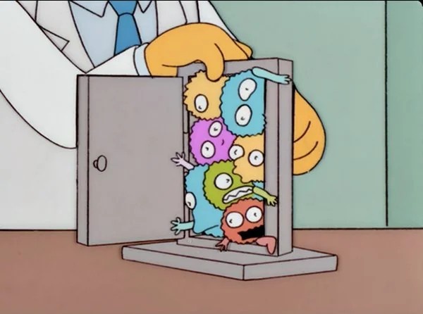 A cartoon scientist in a white coat and blue tie opens a small metal cabinet to reveal a cluster of colorful, multi-eyed…