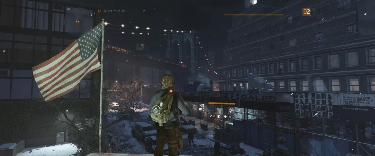 A screenshot from the video game 'The Division' shows a character standing on a snowy rooftop at night overlooking a…