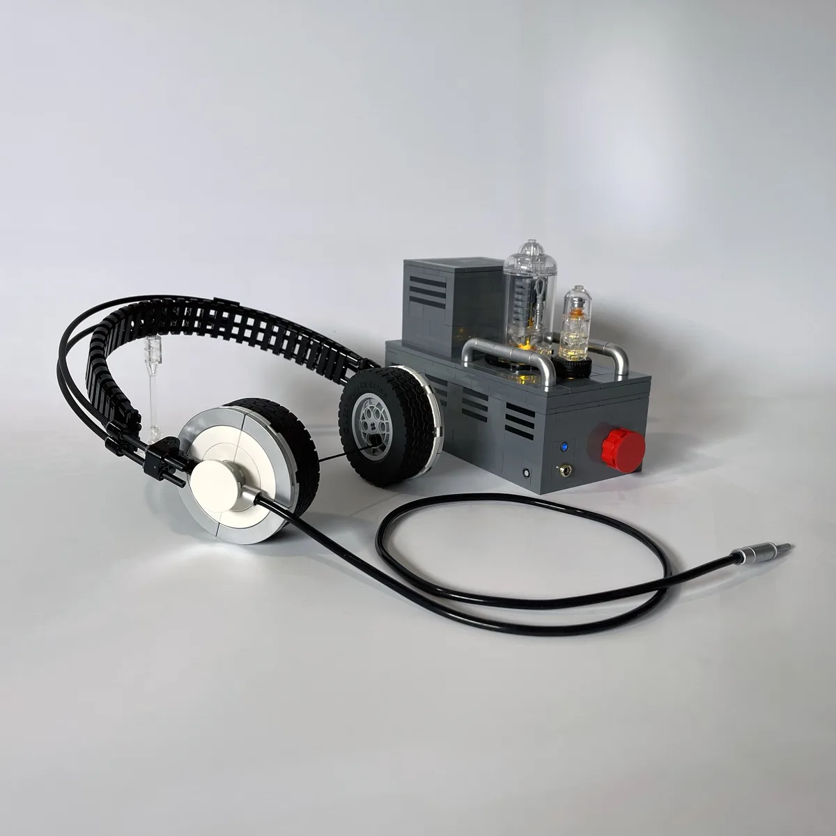 A custom-built headphone and amplifier system constructed entirely from lego bricks, featuring a black over-ear headphone…