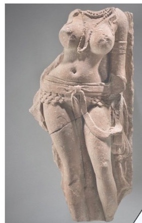 a stone statue of a female figure with exaggerated breasts, a belt, and draped fabric, overlaid with the text 'this is not a…
