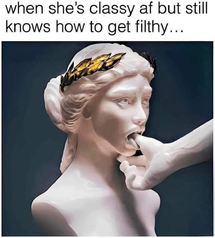 A white marble statue of a woman with a golden laurel wreath on her head, her mouth open as a hand enters from the right to…
