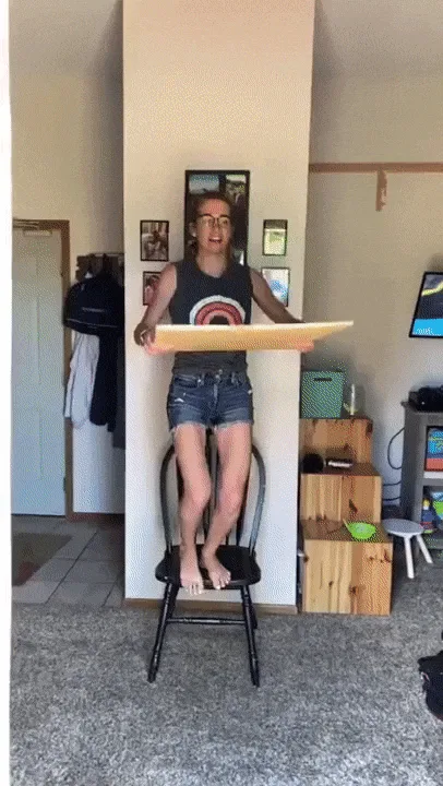 A six-panel image shows a person sitting on a chair, holding a large cardboard cutout. In the first panel, they hold a blank…