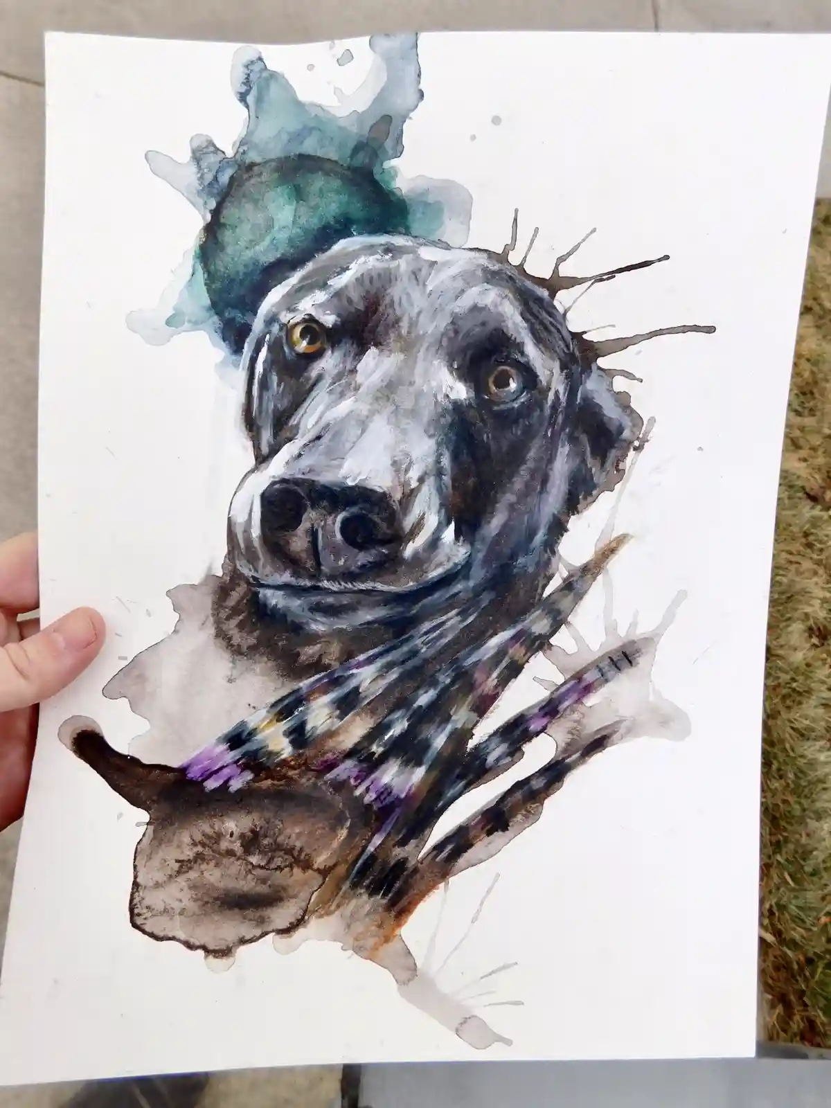 A hand holds up a watercolor painting of a dog's head and shoulders, rendered in expressive, abstract brushstrokes with…