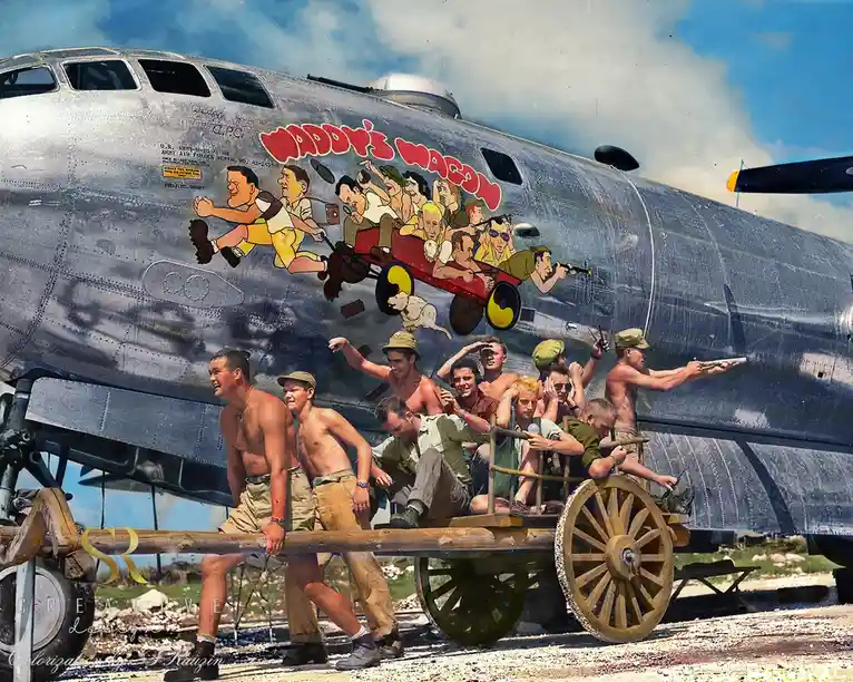 A vintage colorized photo shows a group of shirtless U.S. Army Air Forces soldiers pushing a wooden wagon with a large…