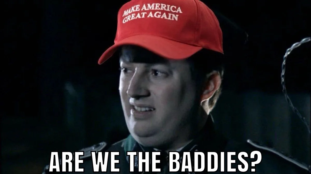 A man wearing a red 'MAKE AMERICA GREAT AGAIN' cap looks sideways with a smug, slightly confused expression. Large white…