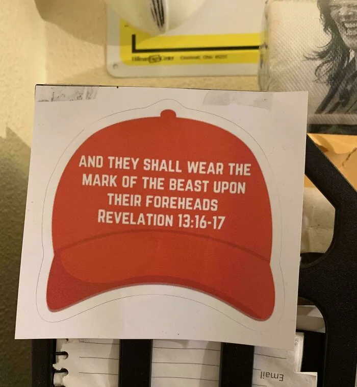 A red baseball cap sticker with white text reading 'AND THEY SHALL WEAR THE MARK OF THE BEAST UPON THEIR FOREHEADS…