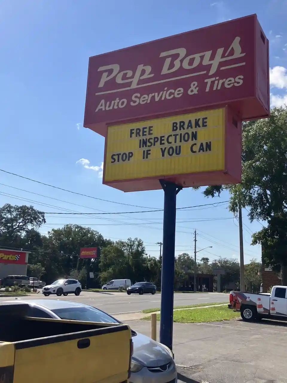 A photo of a red 'Pop Boys Auto Service & Tires' sign with a yellow marquee below it. The marquee displays the text 'FREE…