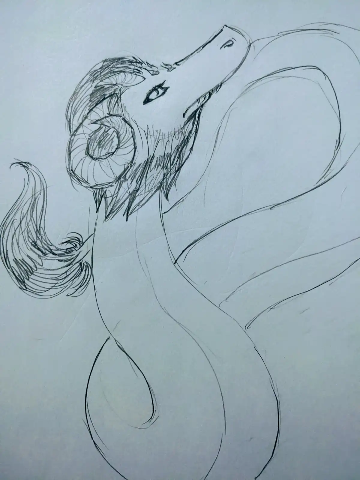 A rough pencil sketch on light paper depicts a stylized, serpentine creature with a large, detailed eye, a small mouth, and…