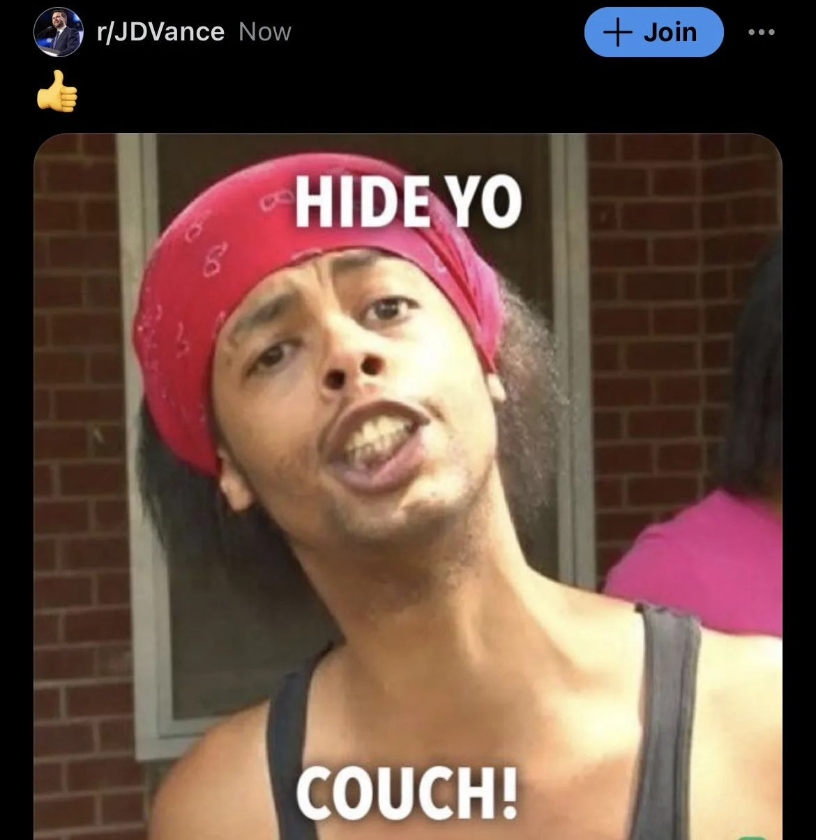 A man with a red bandana and dark tank top stares intensely at the camera with his mouth open, as if shouting. White bold…