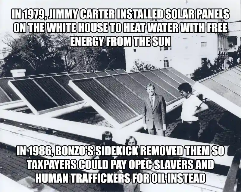 A black-and-white photo shows four men on the roof of the White House, with rows of solar panels installed on the roof. The…