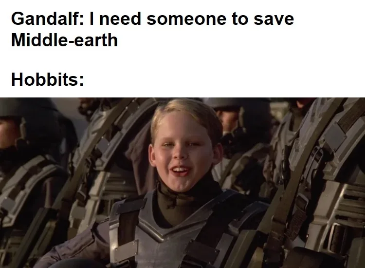 The image shows a young boy in a grey futuristic combat suit, smiling broadly with his mouth open, surrounded by other…
