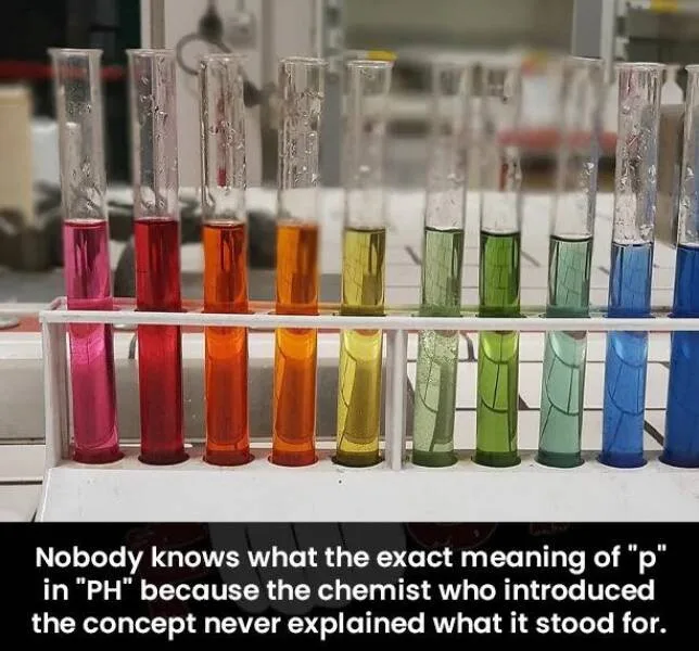 A row of test tubes in a rack, each containing a different colored liquid ranging from pink to blue, arranged in a gradient…