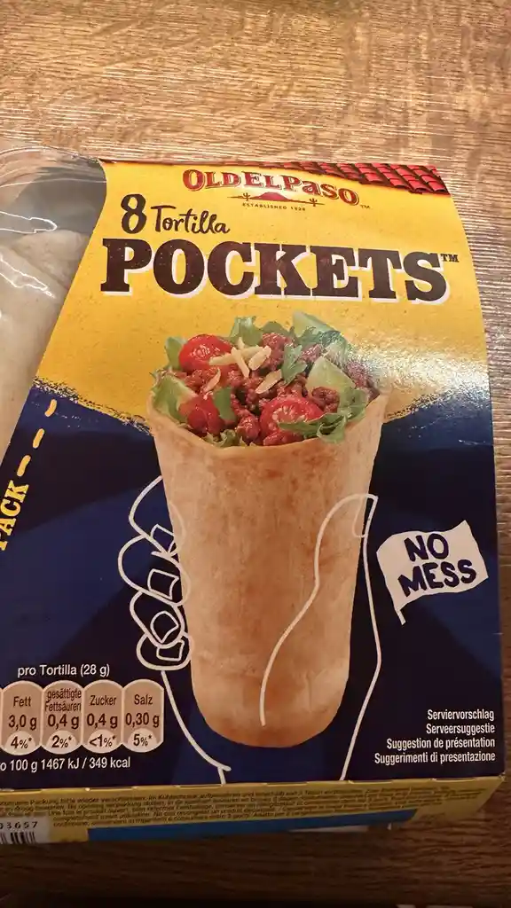 A close-up of an Old El Paso Tortilla Pockets package showing a hand holding a filled tortilla pocket with lettuce…