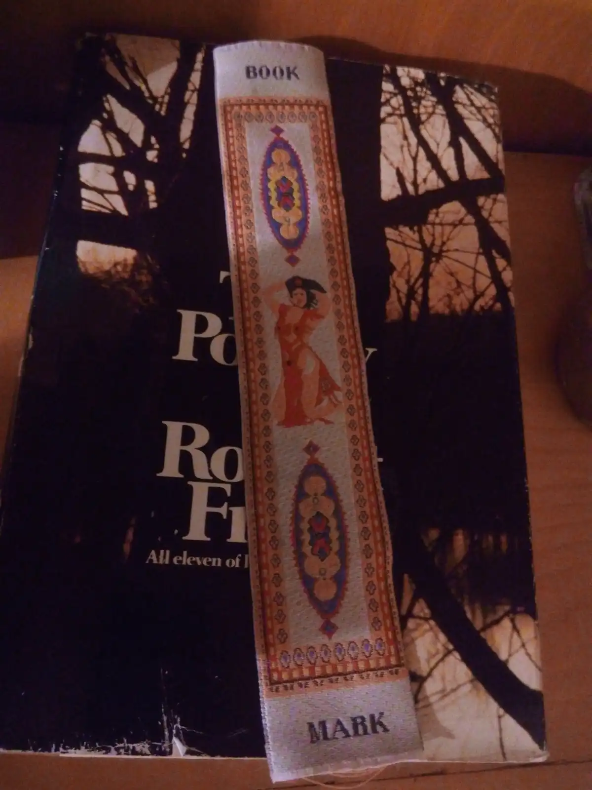 A close-up of a book with a decorative bookmark inserted, showing the word 'BOOK' at the top and 'MARK' at the bottom of the…