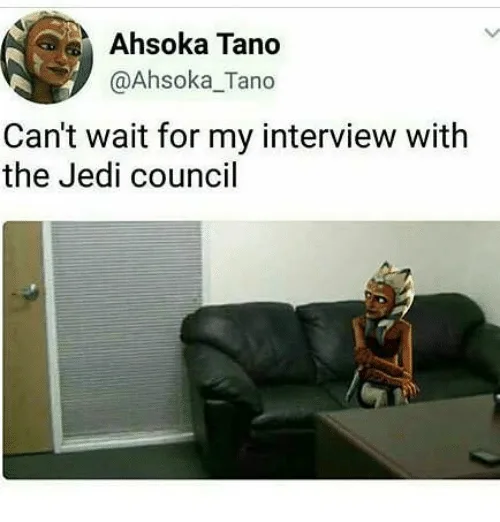 Ahsoka Tano, a character from Star Wars, is shown sitting on a black couch in a plain room with blinds and a door. She has a…