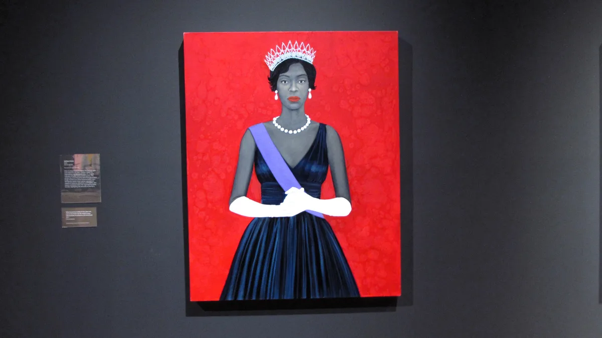 A portrait painting of a Black woman wearing a tiara, pearl necklace, white gloves, and a dark blue gown with a purple sash…