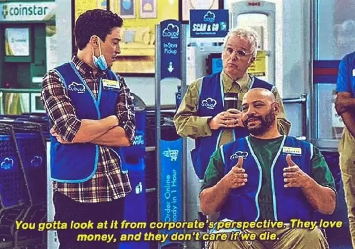 Three employees in blue Cloud 9 vests stand in a retail store with Coinstar machines and 'Scan & Go' signs. The man in the…