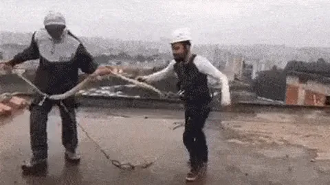 A sequence of six images shows two construction workers on a rooftop holding a long rope, which they use to pull a large…
