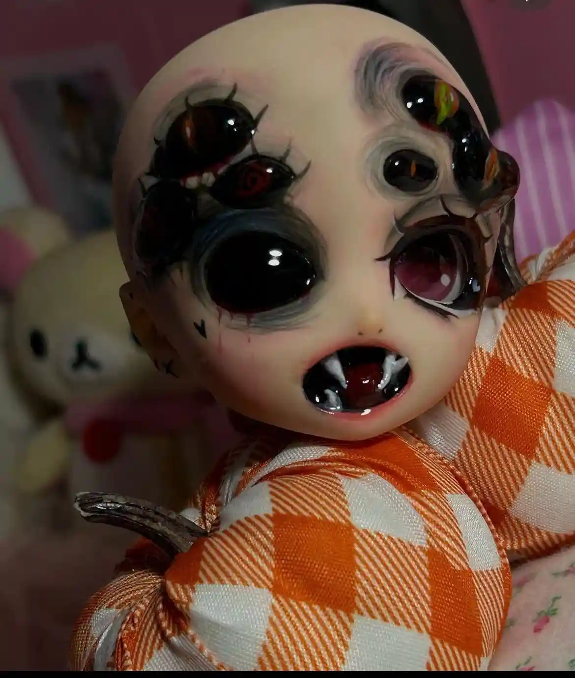 A close-up of a doll with multiple large, glossy eyes, some with red pupils and others with colorful reflections, wearing an…