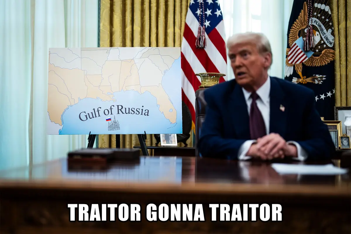 A man in a suit sits at a desk in an office with American flags and curtains, looking shocked. In front of him is a map of…