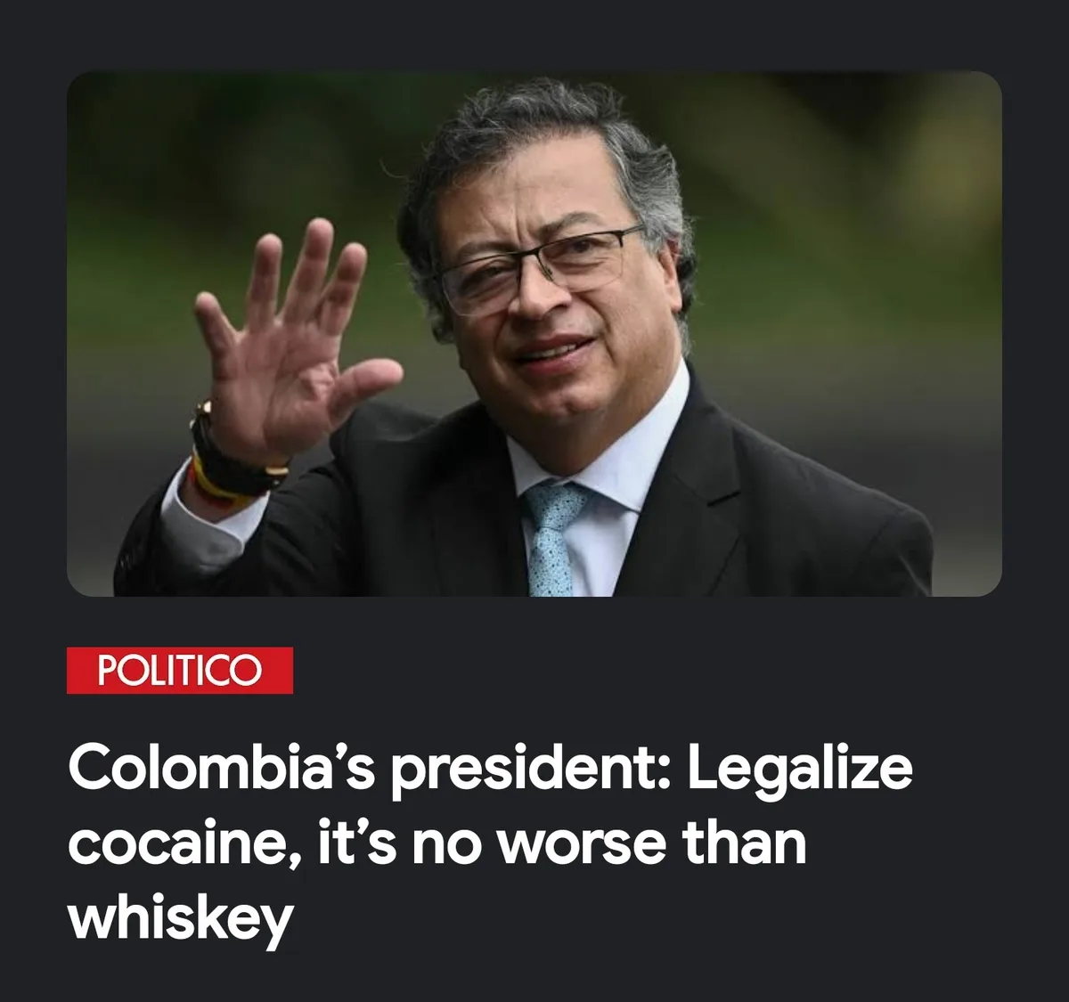 A man in a suit and glasses waves at the camera while wearing a watch and colorful bracelets. Below the image, a Politico…