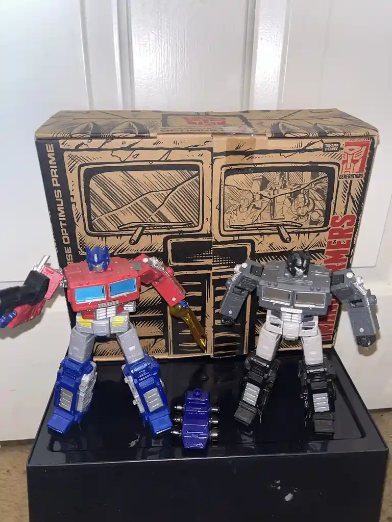 Two Transformers action figures, Optimus Prime (red, blue, and silver) and Megatron (gray, black, and silver), stand…