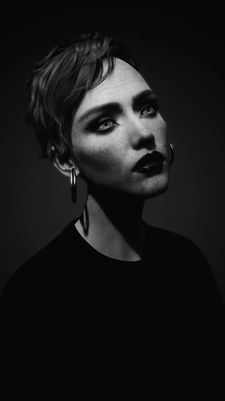 A black-and-white portrait of a person with short, tousled hair, dark lipstick, and hoop earrings, looking upward with a…