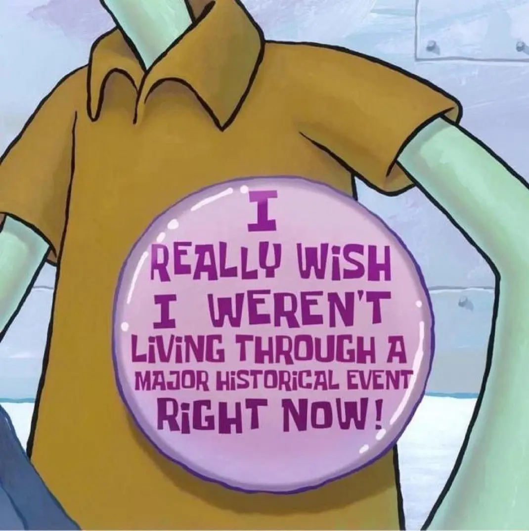 A close-up of the animated character SpongeBob SquarePants wearing a yellow shirt, with a large pink circular button pinned…