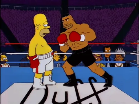The image shows a sequence of frames from The Simpsons where Homer Simpson, in boxing gear, faces a much larger, muscular…