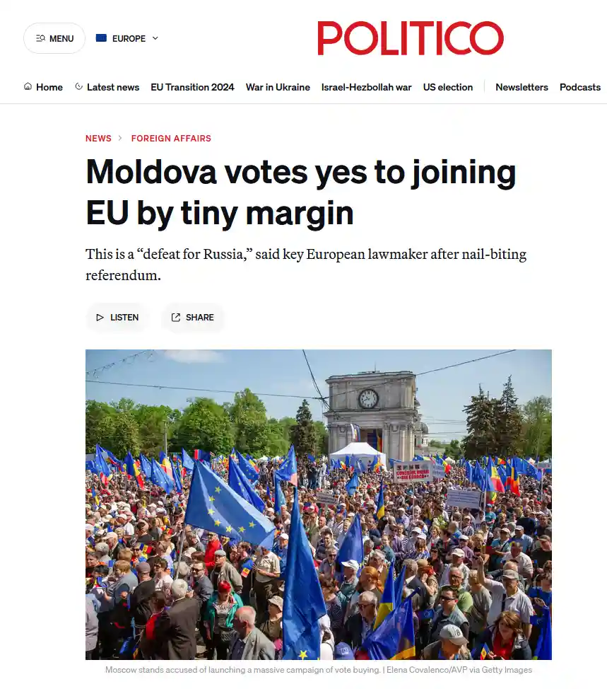 A screenshot of a Politico news article showing a large crowd of people holding European Union and Moldovan flags…