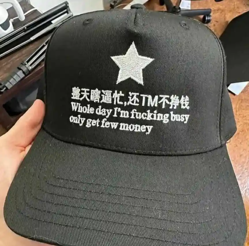 A black baseball cap with a white embroidered star and text in both Chinese and English. The Chinese text reads…