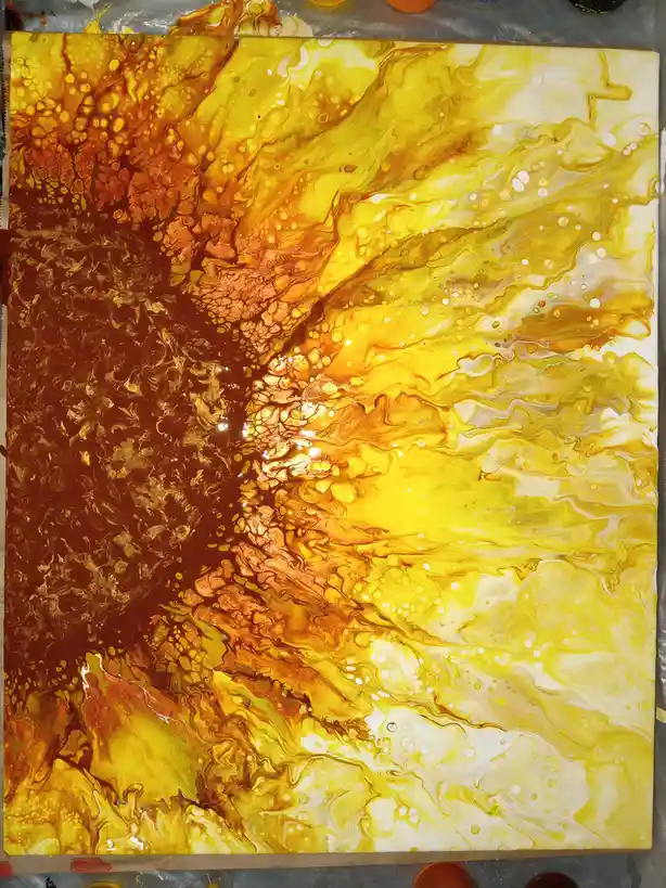 A close-up photo of a vibrant, abstract fluid art painting on a canvas, featuring swirling patterns of gold, yellow, orange…