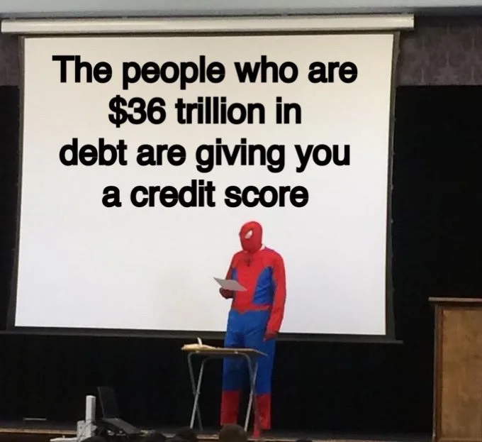A person in a Spider-Man costume stands on a stage in front of a large projection screen. The screen displays the text: 'The…