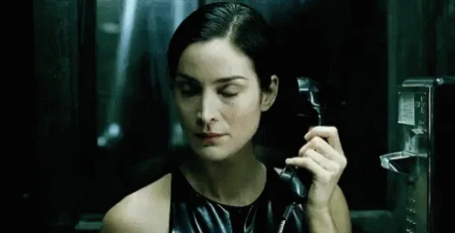 A six-panel image sequence shows a woman in a dark, metallic room holding a telephone receiver. In the first three panels…