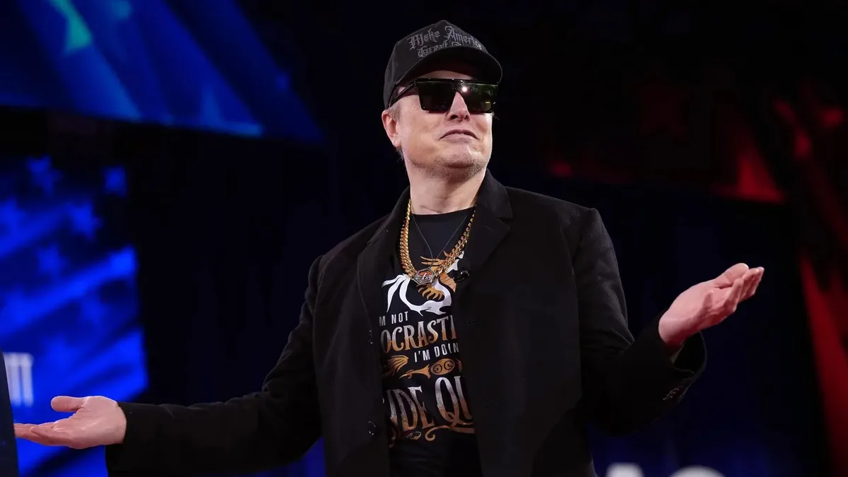 elons t-shirt reads i'm not procrastinating i'm doing a side quest while he wears a black cap and sunglasses and shrugs with…