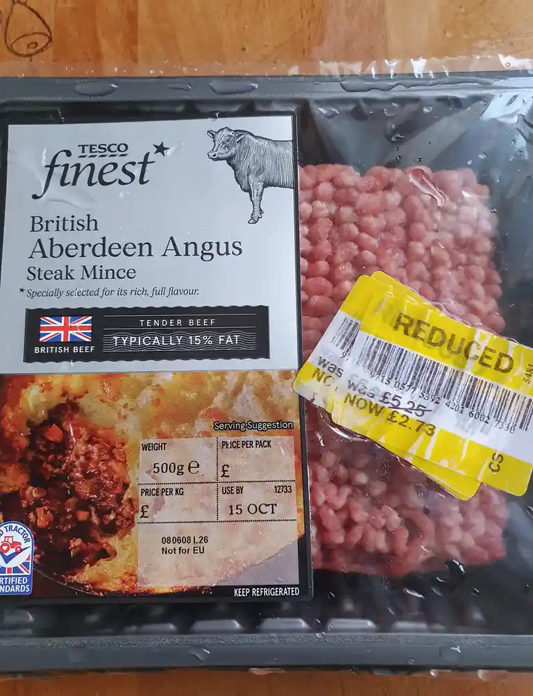 A close-up of a Tesco Finest British Aberdeen Angus Steak Mince package, showing the meat inside and a yellow 'REDUCED'…