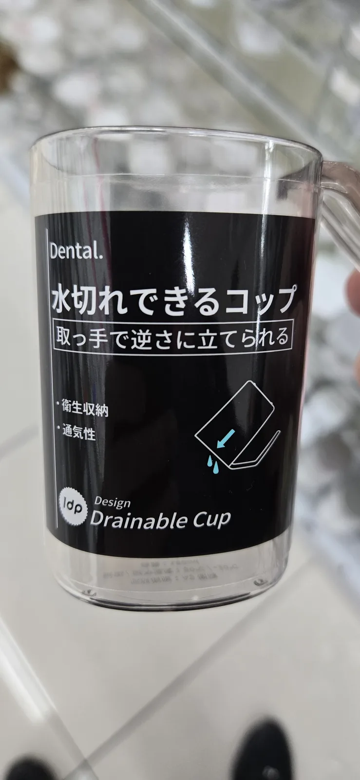 A clear plastic cup with a black label featuring Japanese text and an illustration of a cup draining. The label reads…