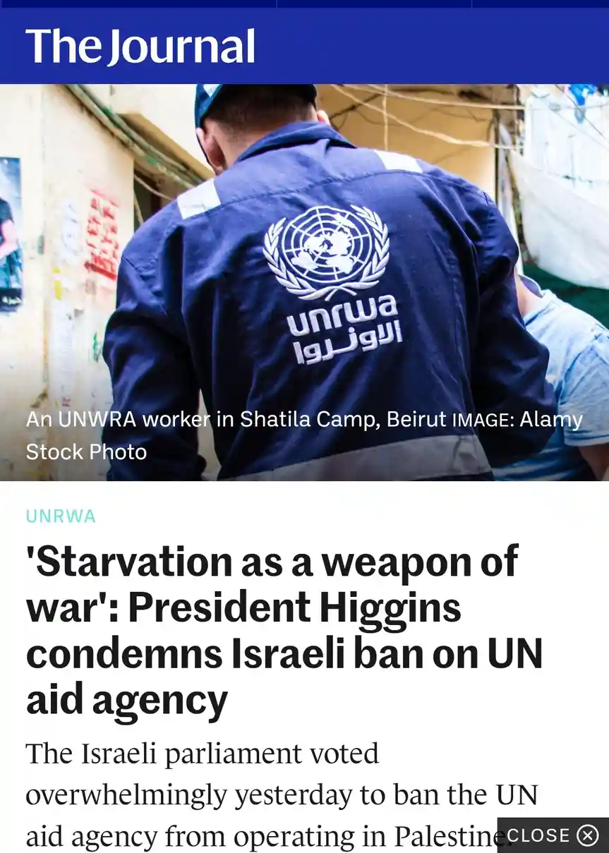 A stock photo from 'The Journal' shows the back of a UNRWA worker in a blue uniform with the UNRWA logo and Arabic text…