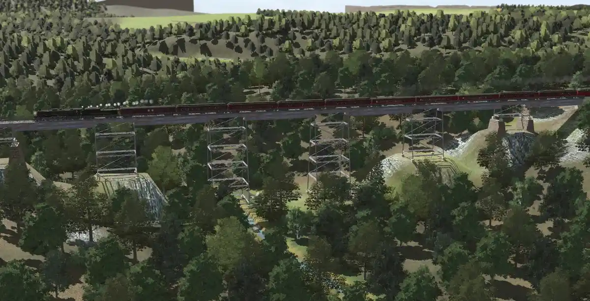 A screenshot from a train simulation game shows a steam locomotive pulling red passenger cars across a tall metal truss…