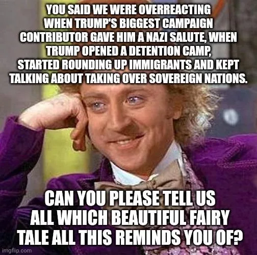 A man with curly hair and a purple suit rests his chin on his hand with a smug, knowing smile. Overlaid text accuses someone…