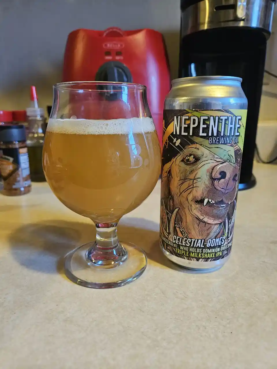 A can of Nepenthe Brewing Co.'s 'Celestial Bones' Triple Milkshake IPA sits next to a glass filled with the beer, which has…