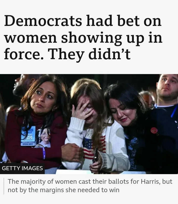 The image shows a group of women at what appears to be a political event, with one woman visibly crying while being…