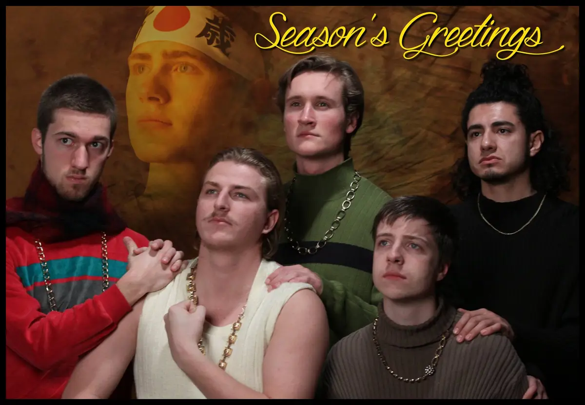 Five young men in 1980s-style clothing with gold chains pose together, looking serious or blankly at the camera. Behind…