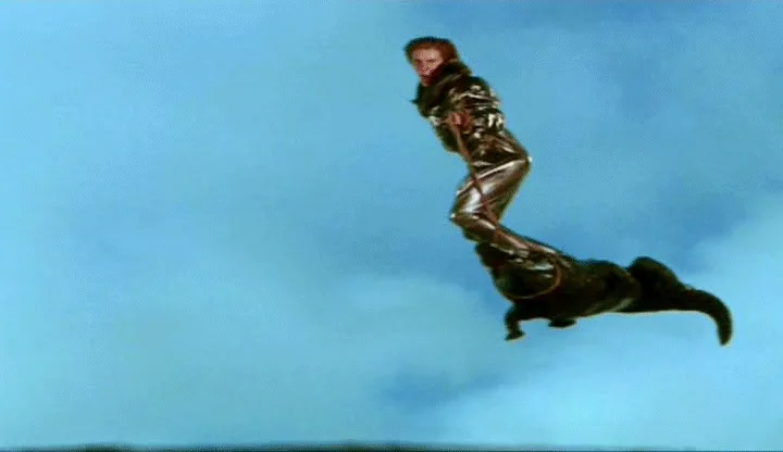 A six-panel sequence shows a woman in a shiny silver suit falling through the sky, then grabbing onto a crocodile mid-air…