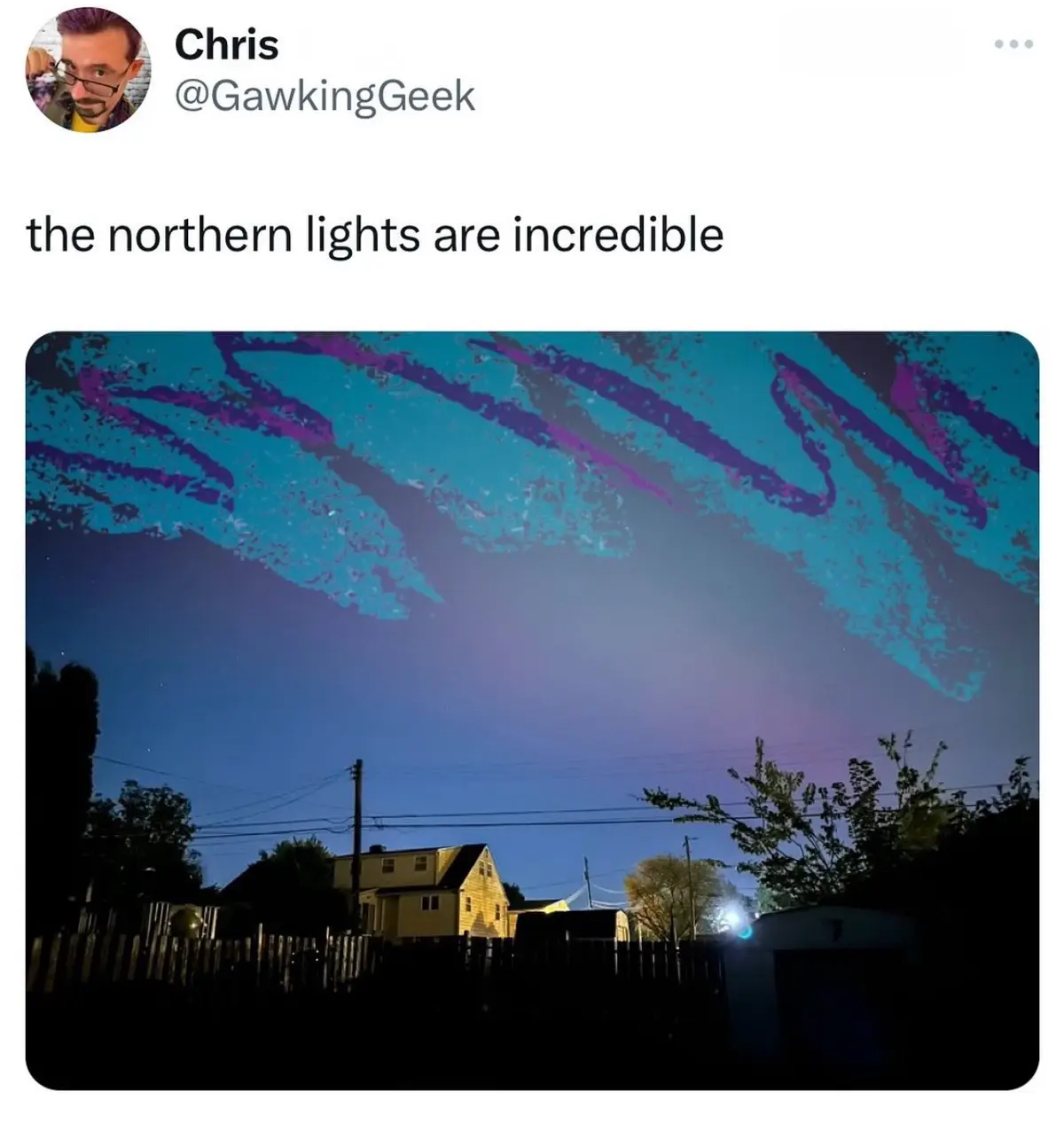 A screenshot of a tweet by Chris @GawkingGeek shows a night sky over a suburban neighborhood with a house, fence, and trees…